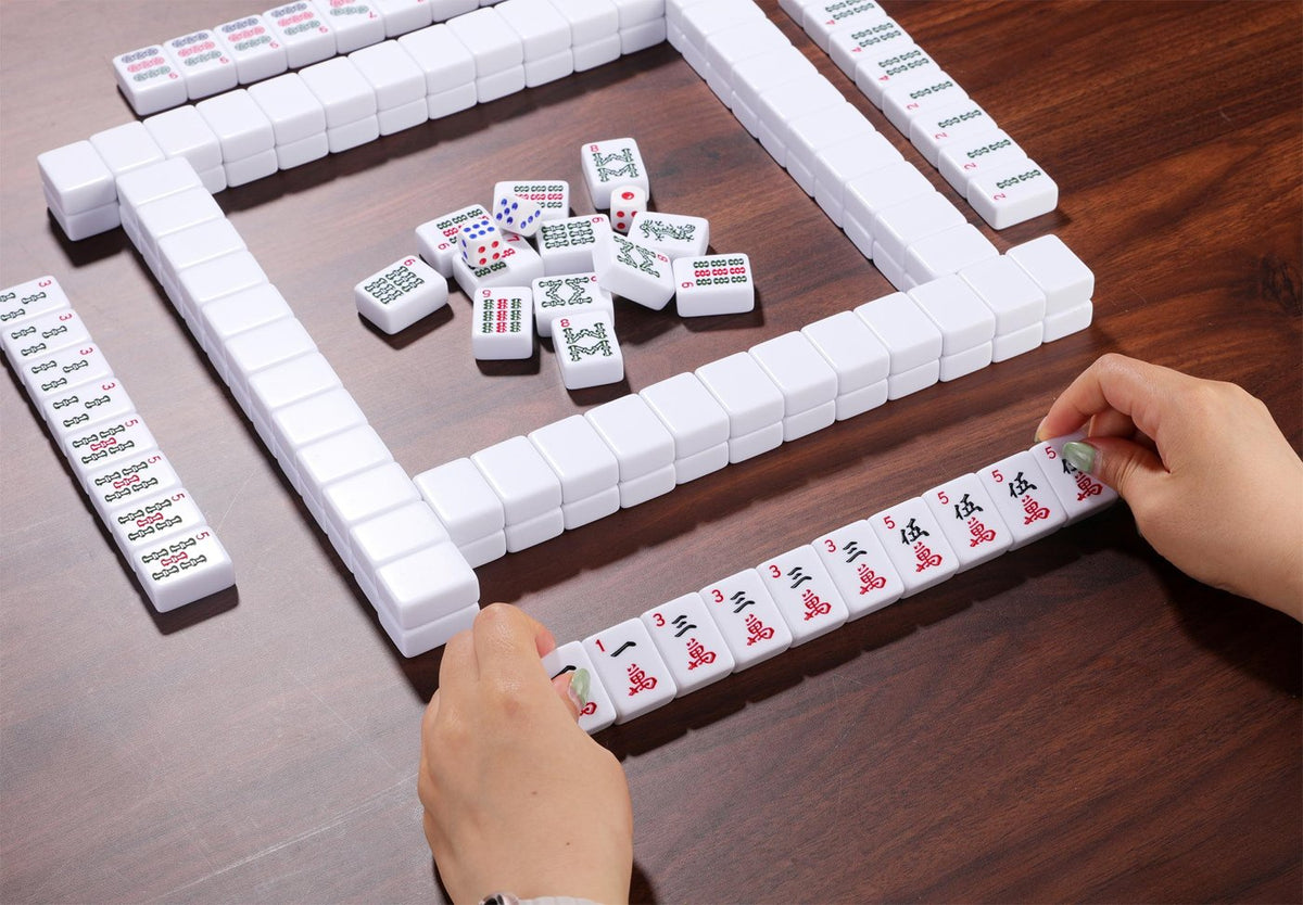 Hands arranging tiles during a game