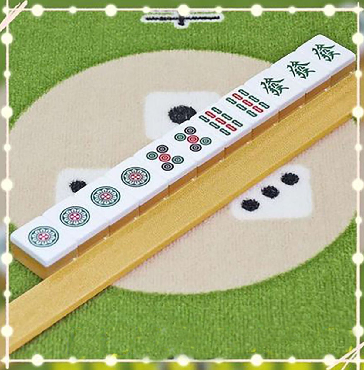 Chinese mahjong tiles lined up against a gold ruler